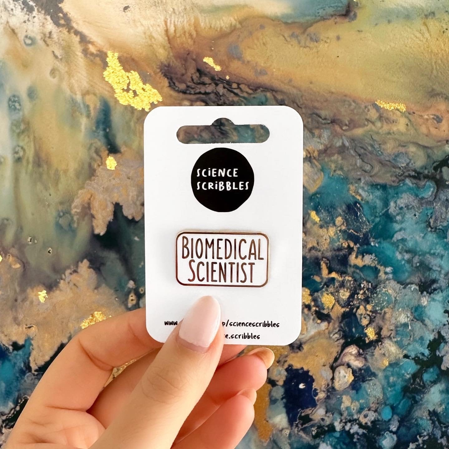 Card with 'Biomedical Scientist' text held against a textured, multicolored background