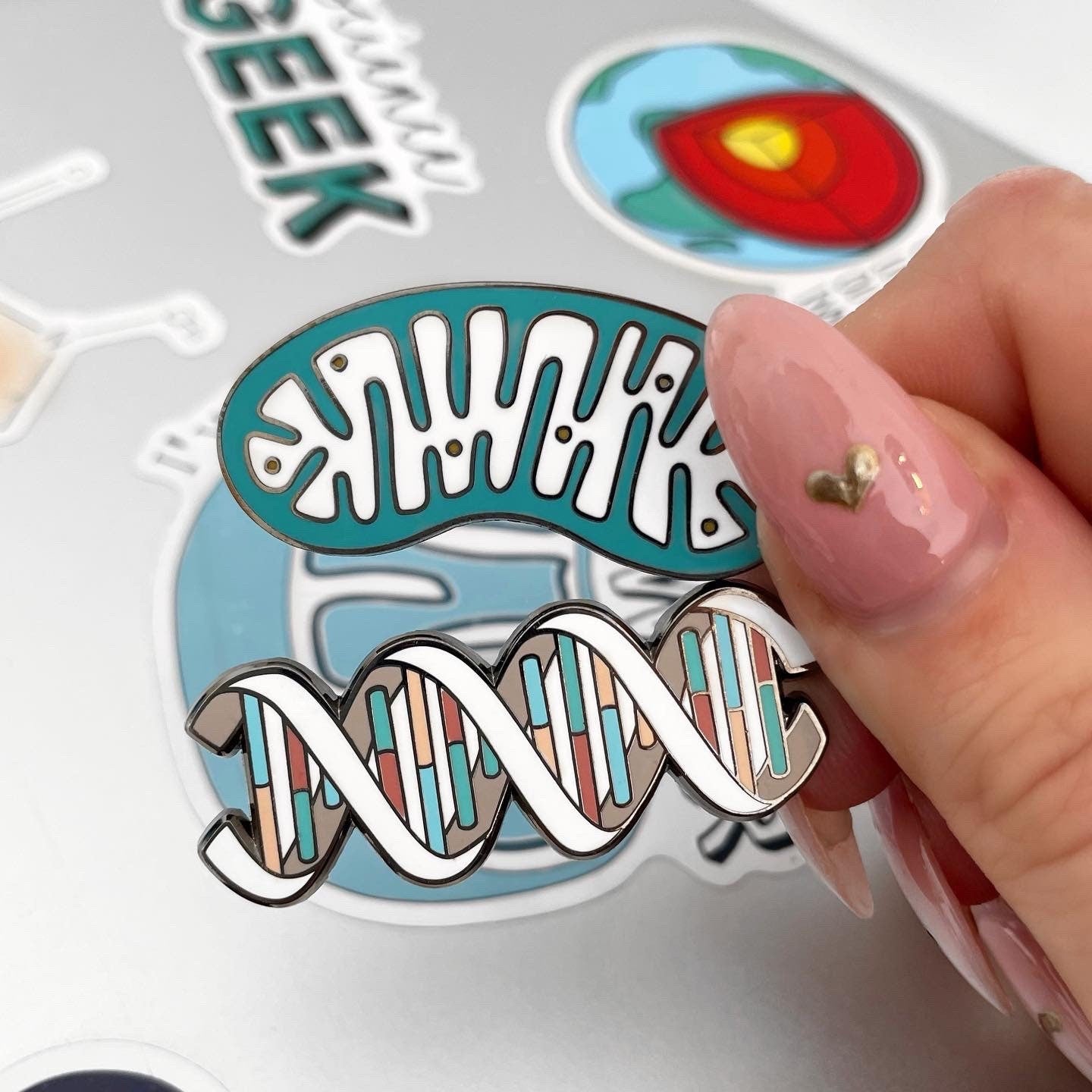 Hand holding a DNA and mitochondria keyrings