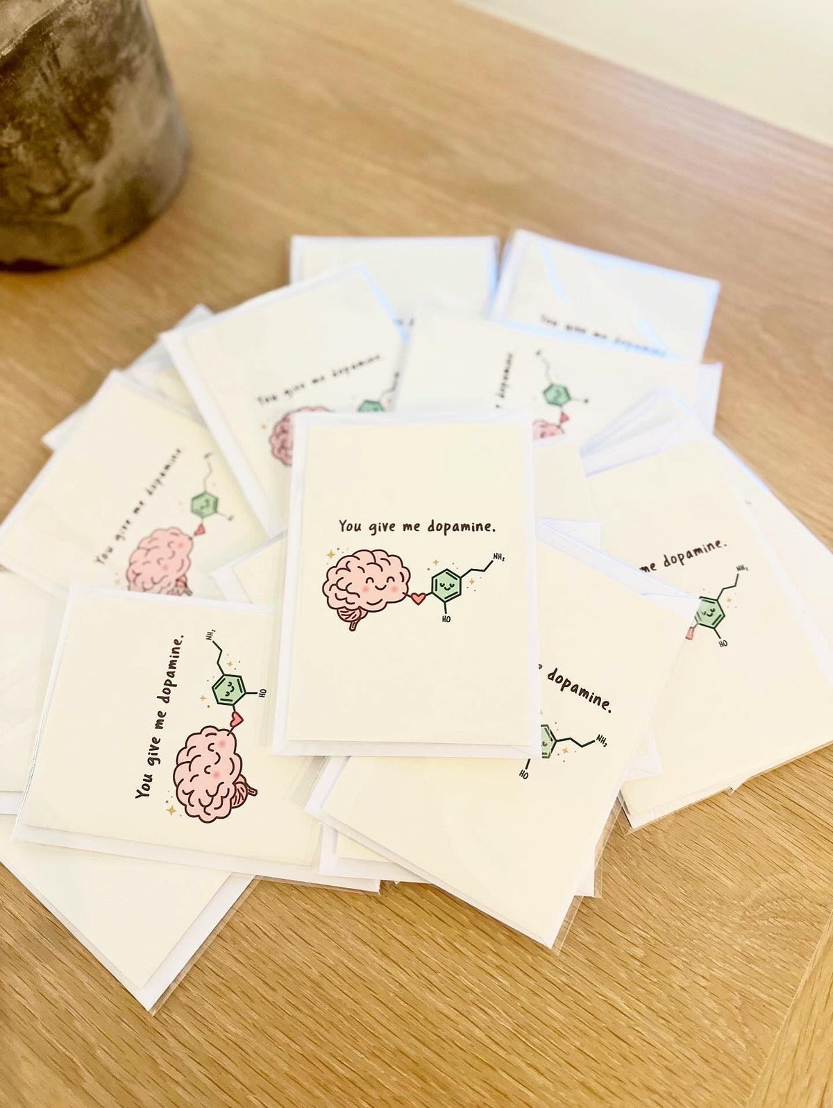 Stack of small cards with brain and chemical molecule illustrations on a wooden surface