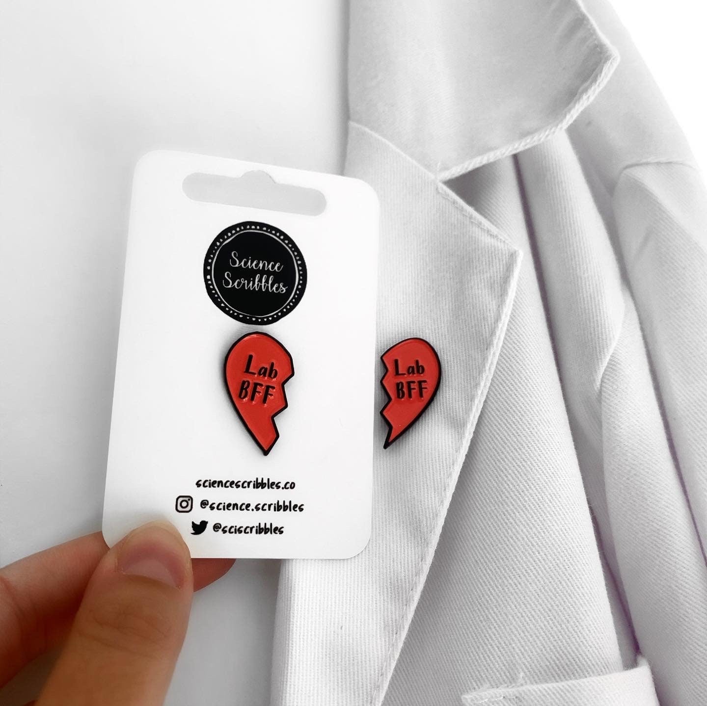 Red heart-shaped earrings with 'Lab BFF' text on a white card held against a white shirt.