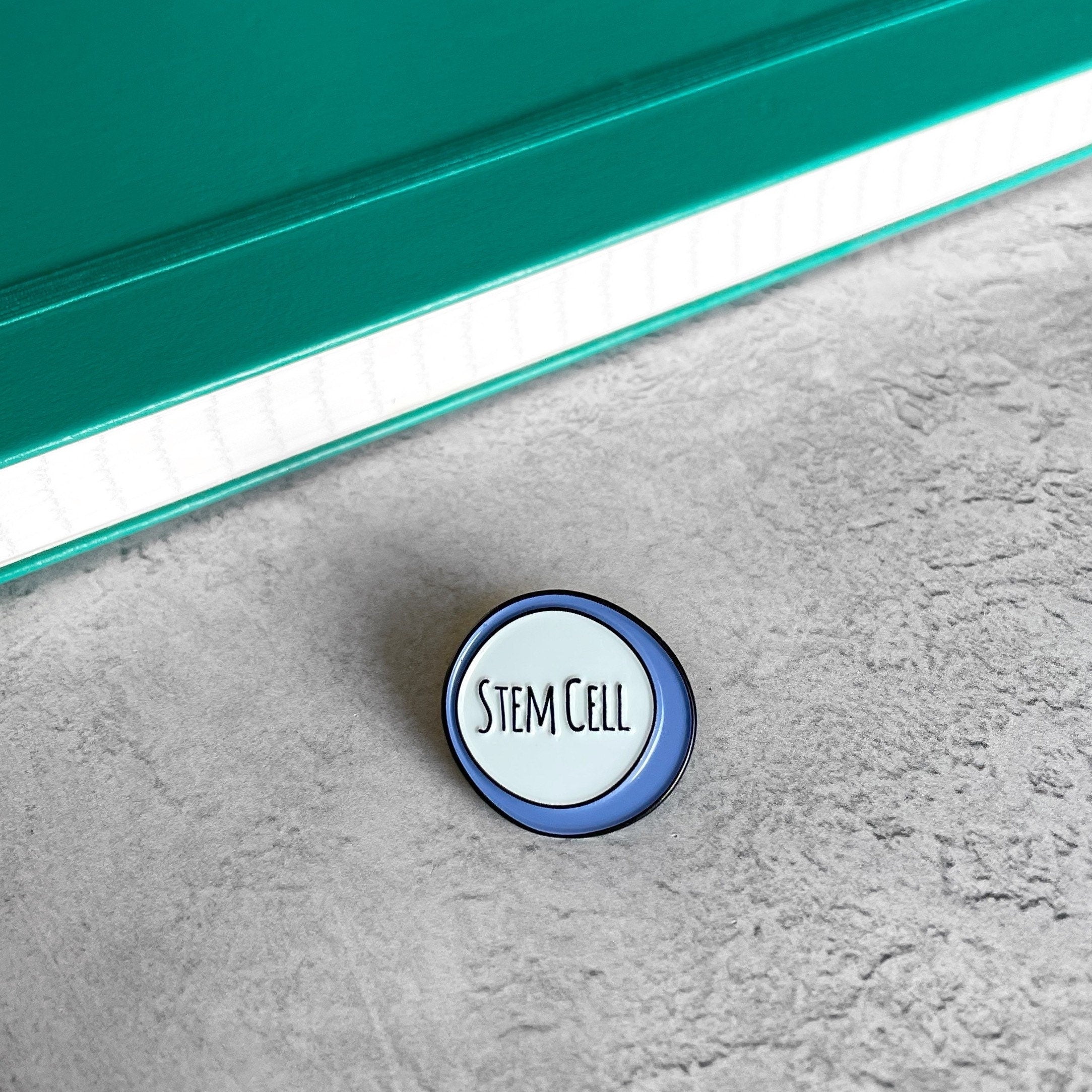 Round badge with 'STEM CELL' text on a textured surface