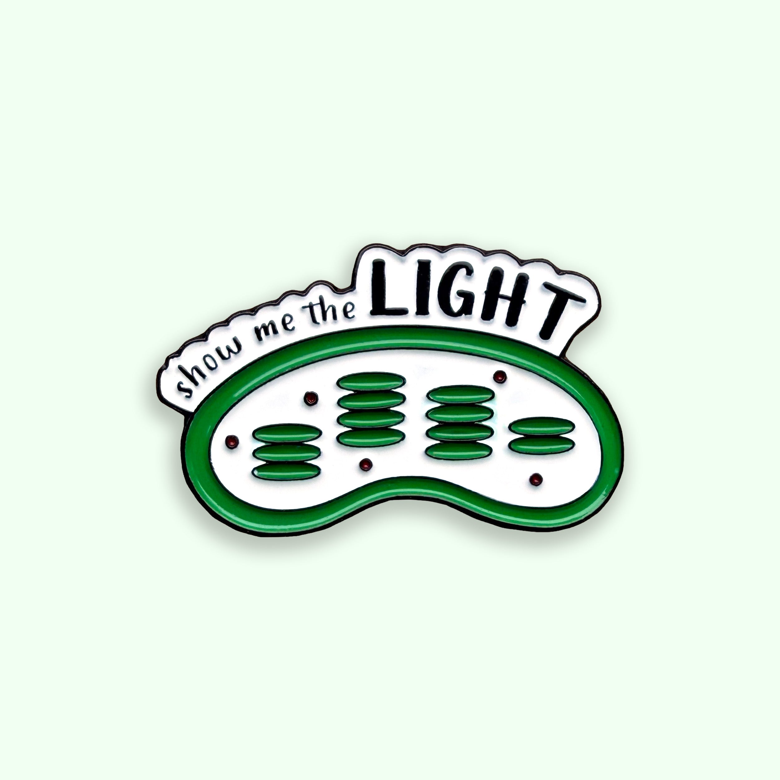Enamel pin with 'show me the LIGHT' text and green design on a white background