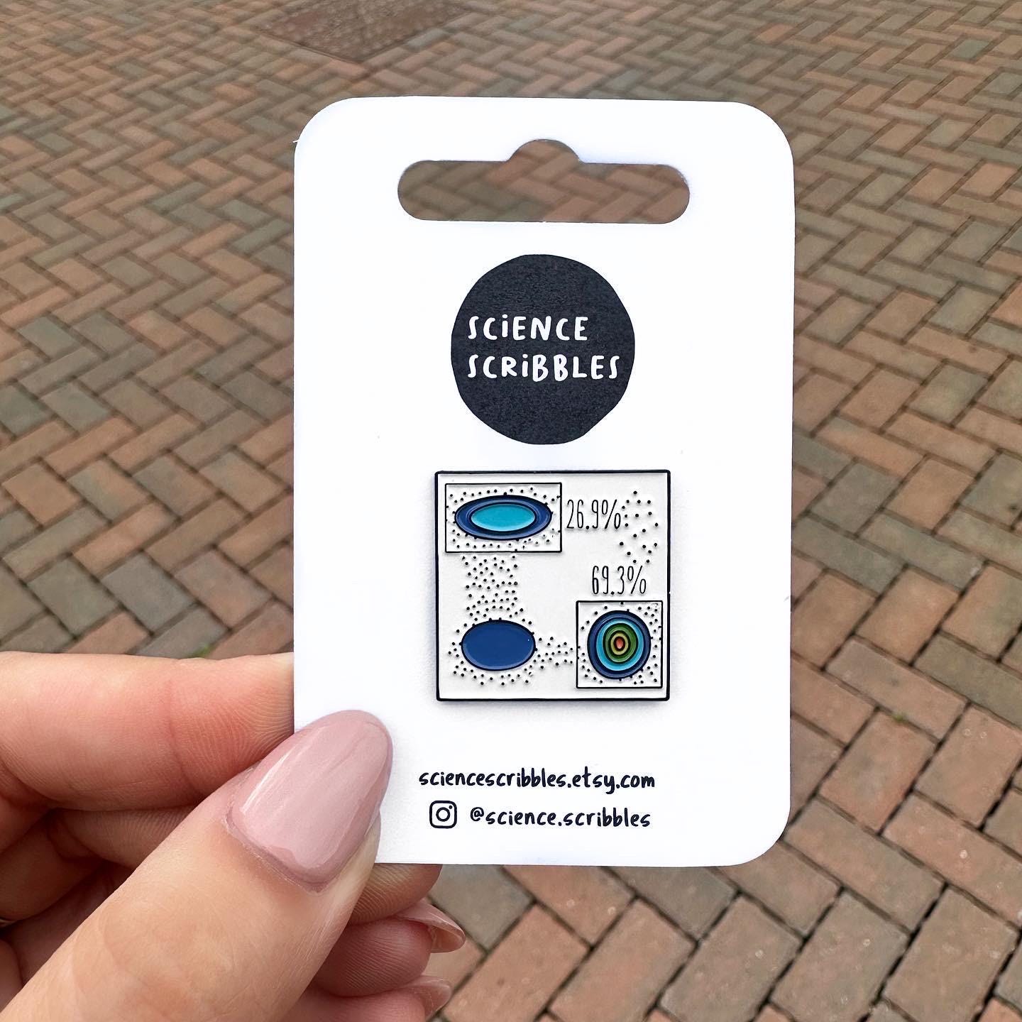 Enamel pin of a flow cytometry plot with gating over the x and y axis pseudoplot populations on pin backing card