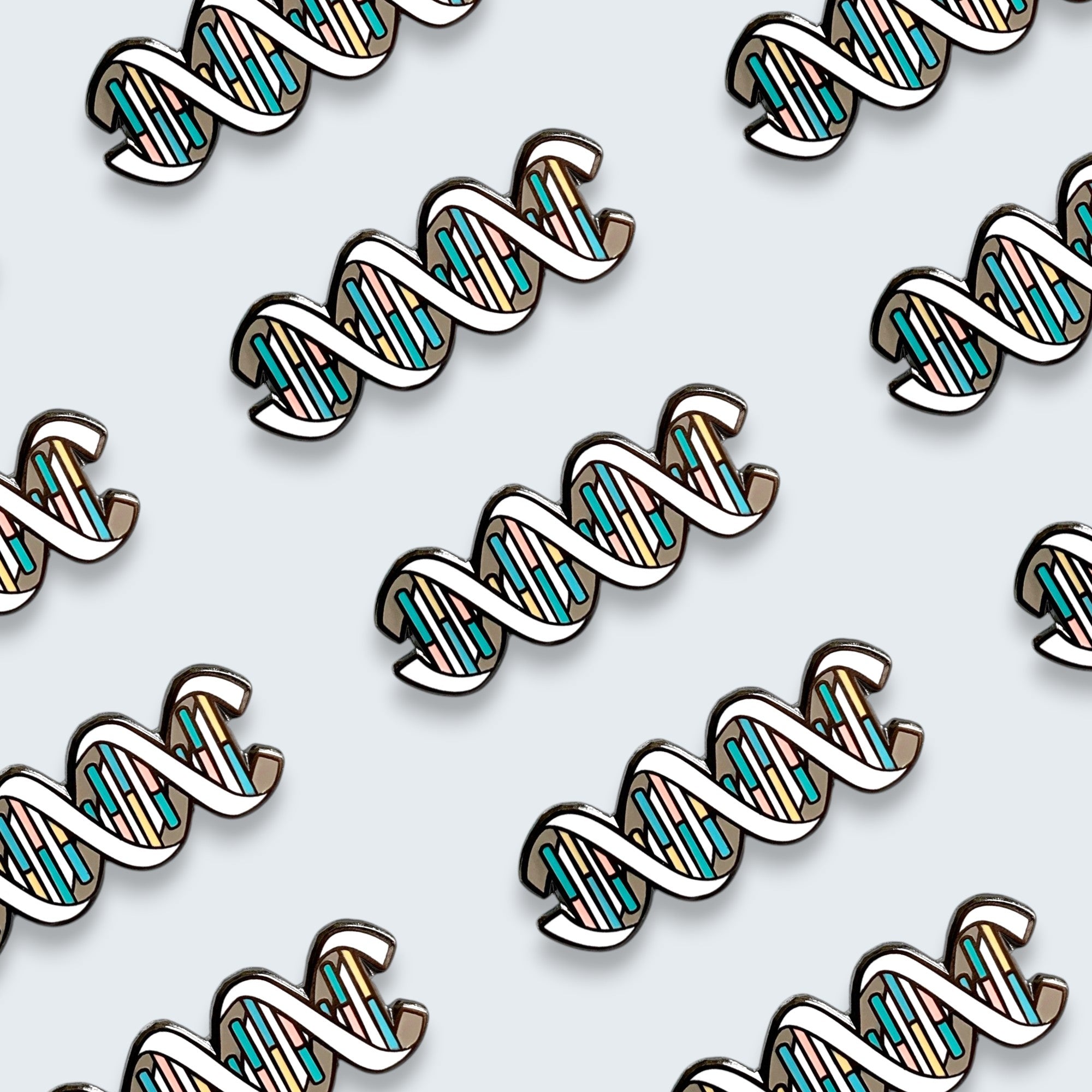 Multiple DNA enamel pins on a blue background