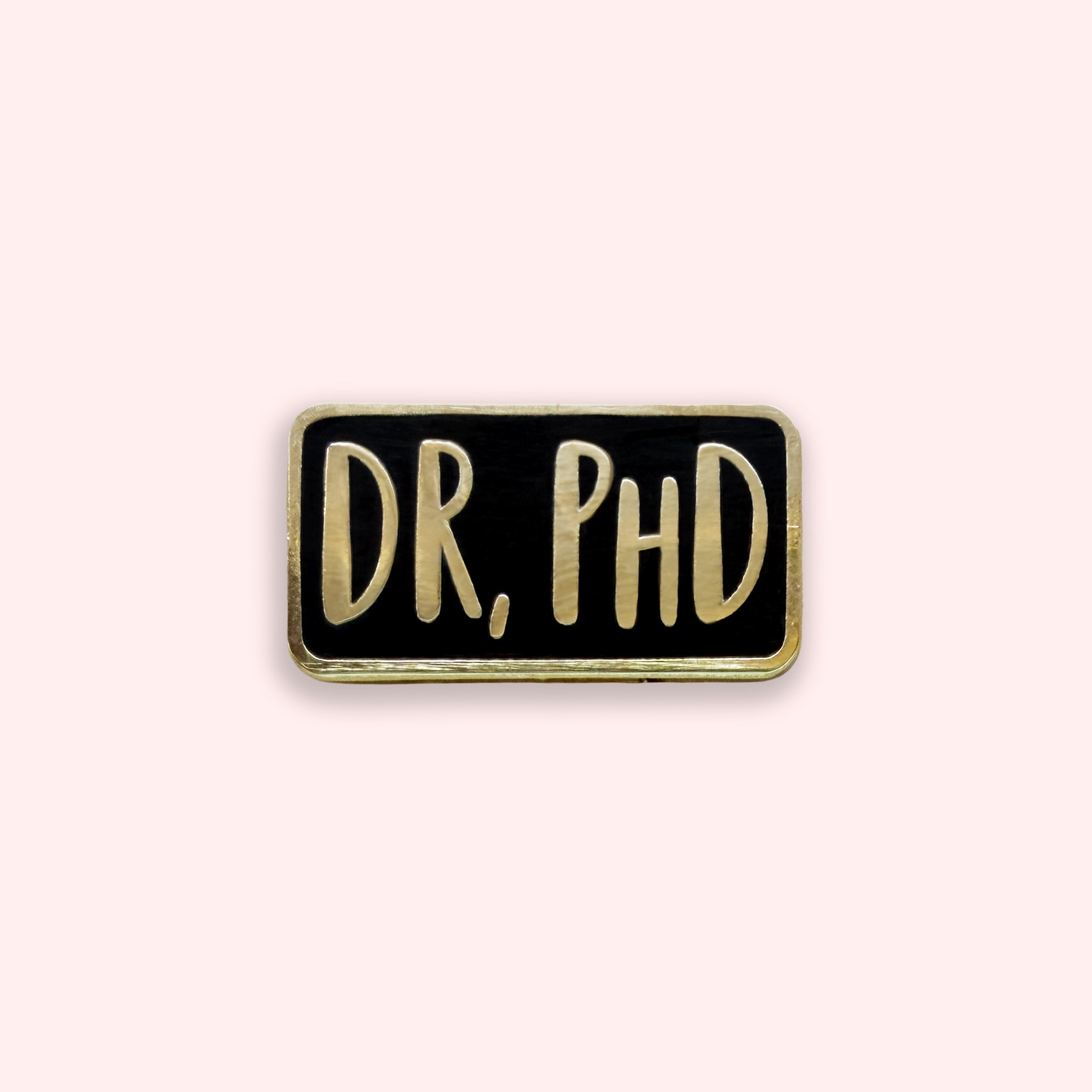 Back and gold enamel pin with the word 'Dr, PHD' on it
