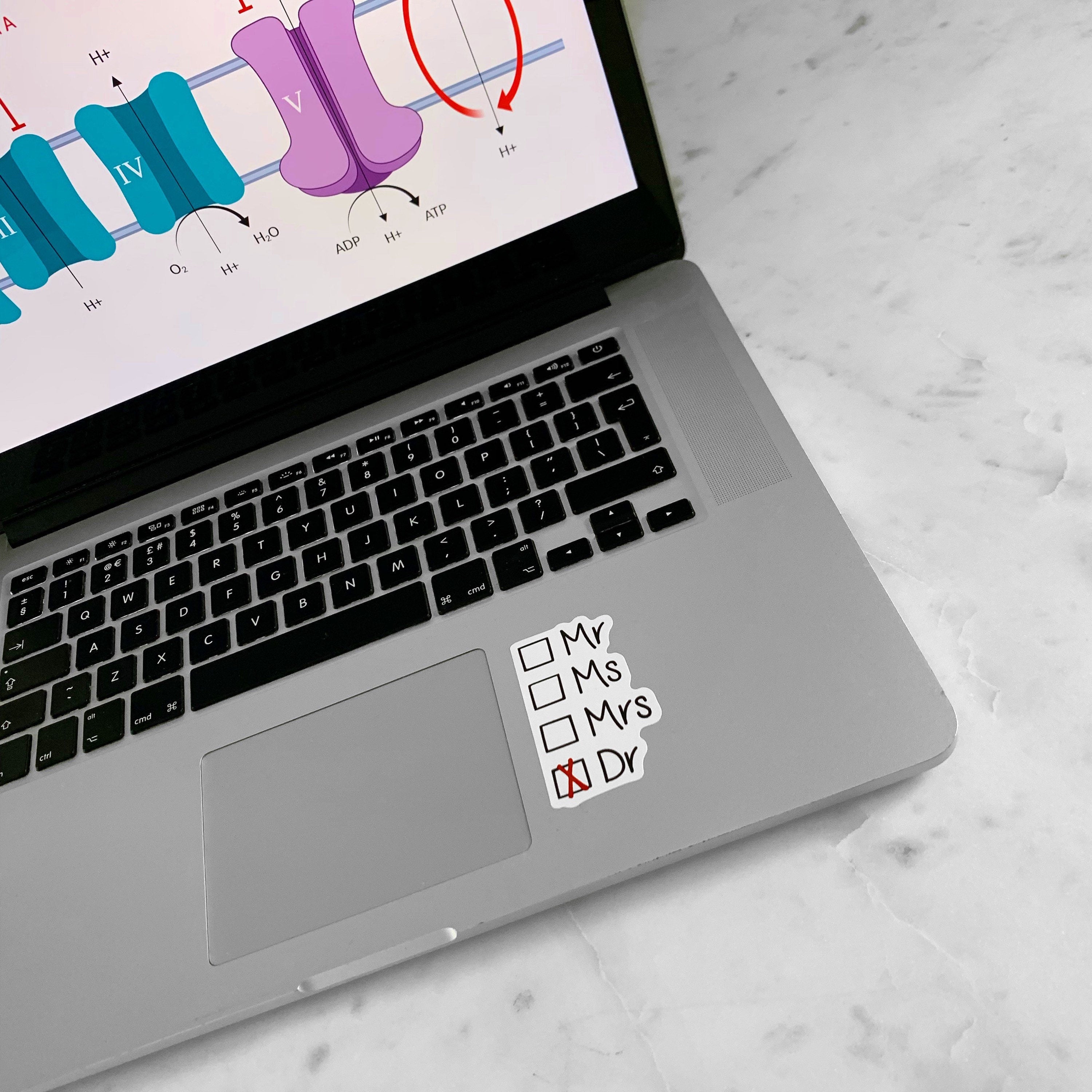 Laptop with a Dr sticker on the trackpad.