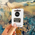 Pin with 'Biomedical Scientist' text on a card held against a textured background