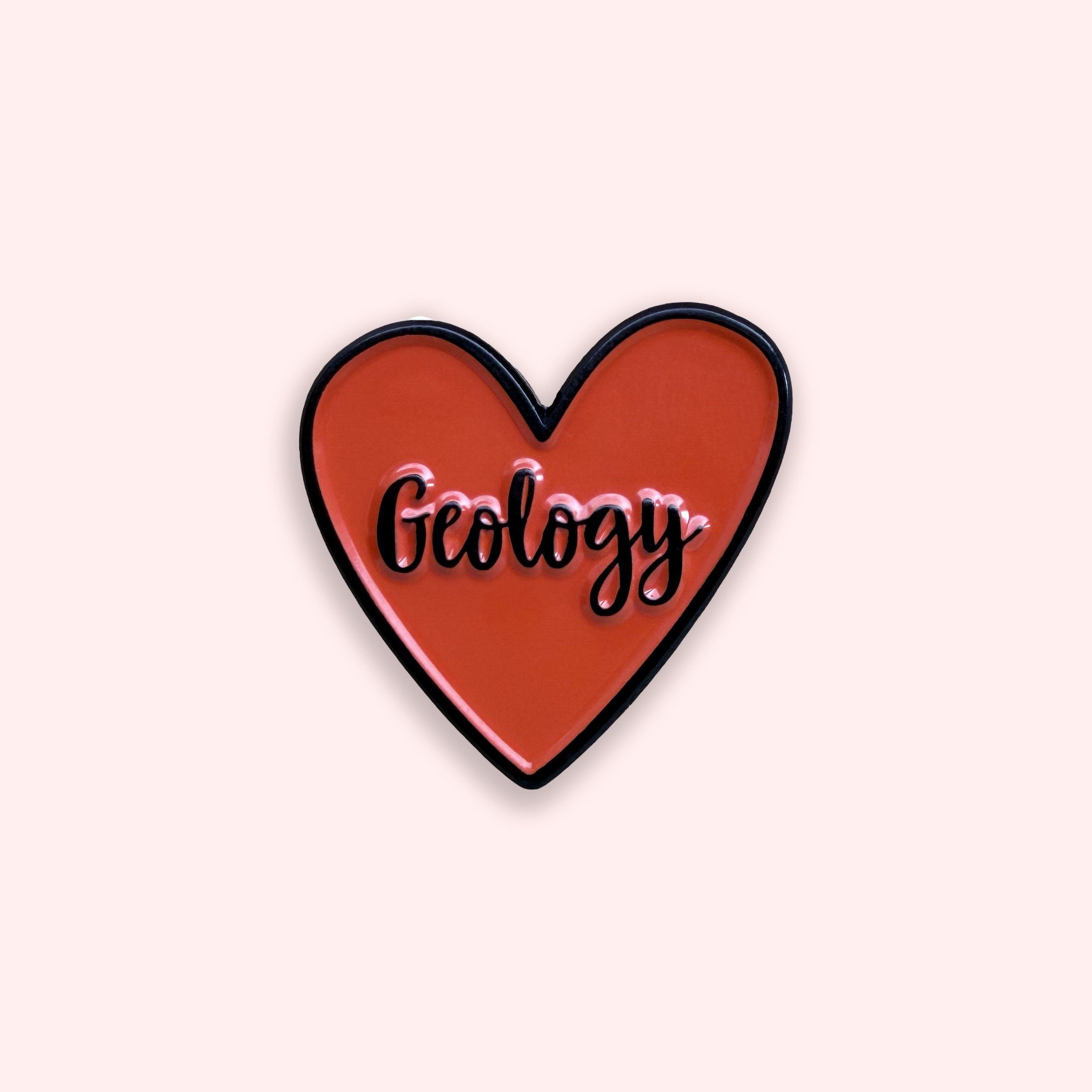 Heart-shaped pin with 'Geology' text on a light pink background