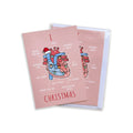 A pink Christmas greeting card with an anatomical heart illustration and the word 'CHRISTMAS' printed on it, shown on a pale pink background.