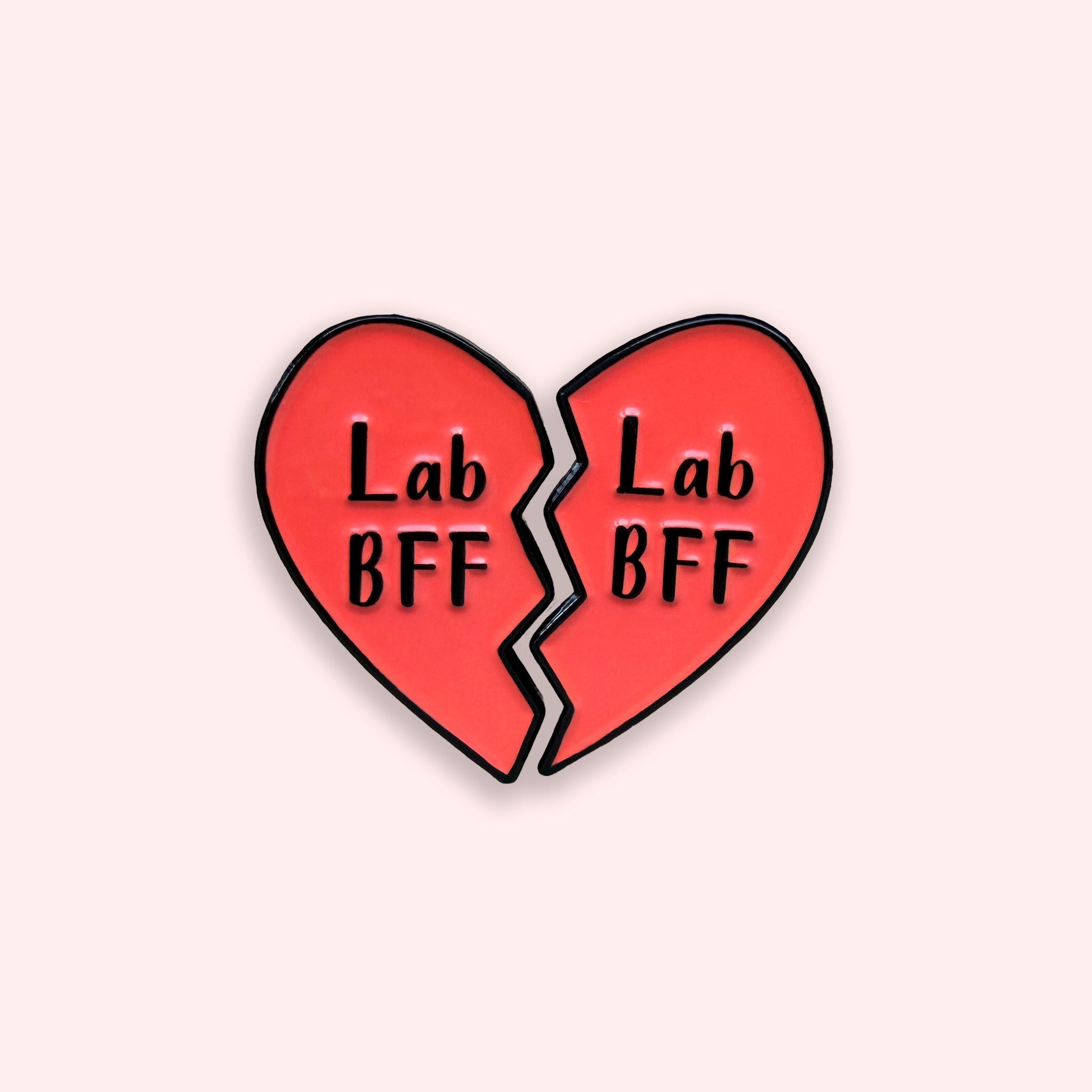 Lab BFF red heart matching enamel pins on a pink background