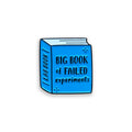 Blue enamel pin shaped like a lab book with 'Big Book of Failed Experiments' text on a white background