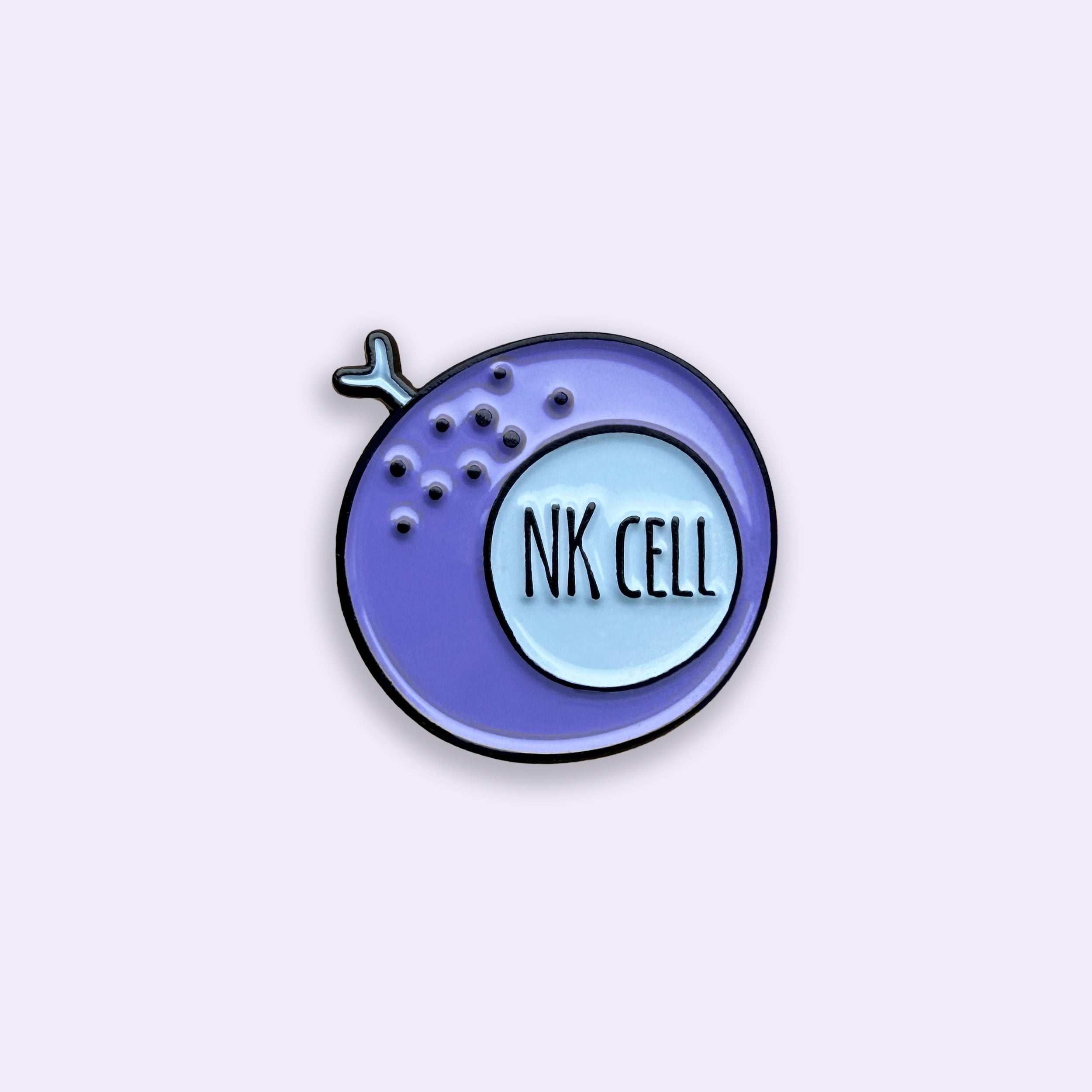 Enamel pin with 'NK Cell' text on a light purple background
