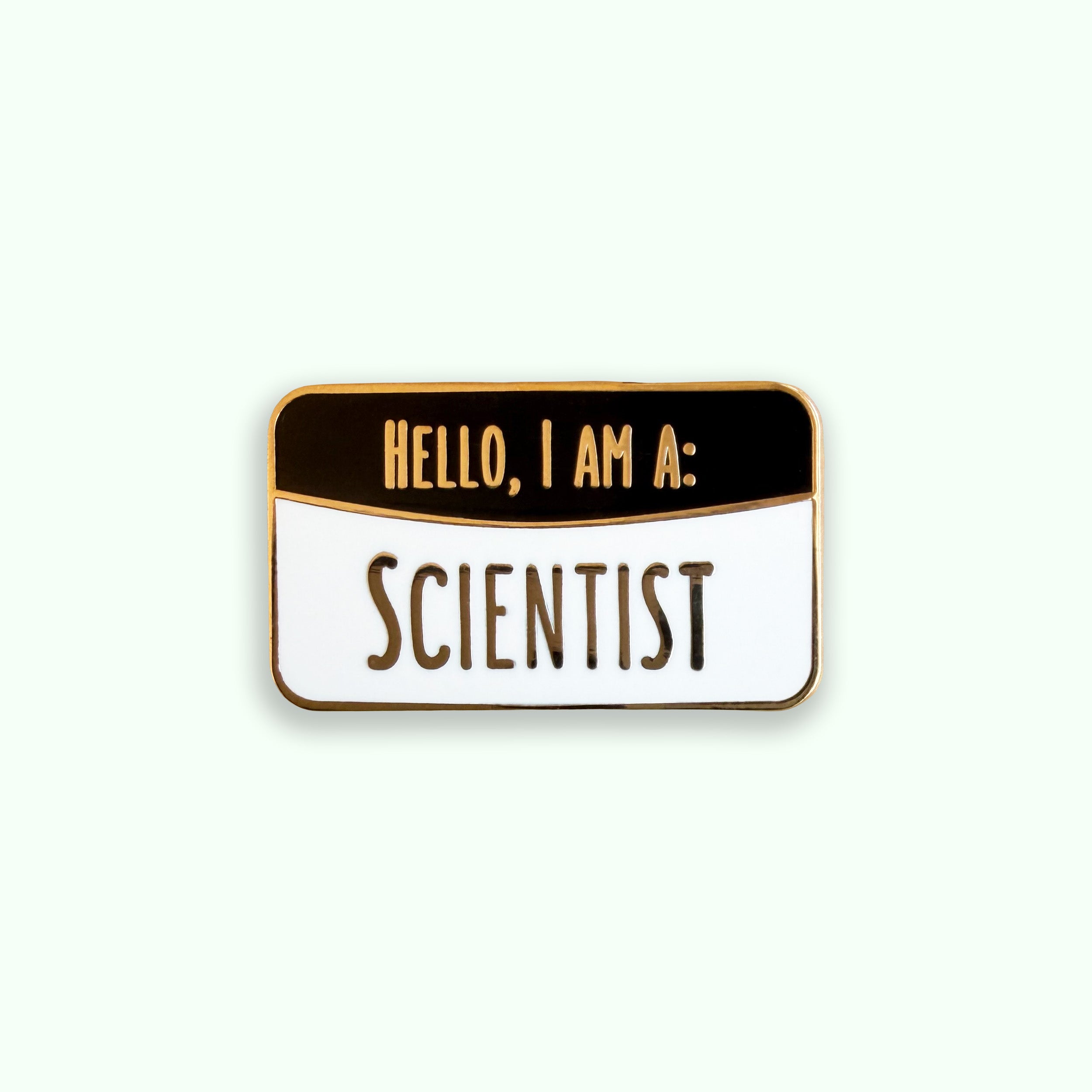 Enamel pin with 'Hello, I am a: Scientist' text on a green background
