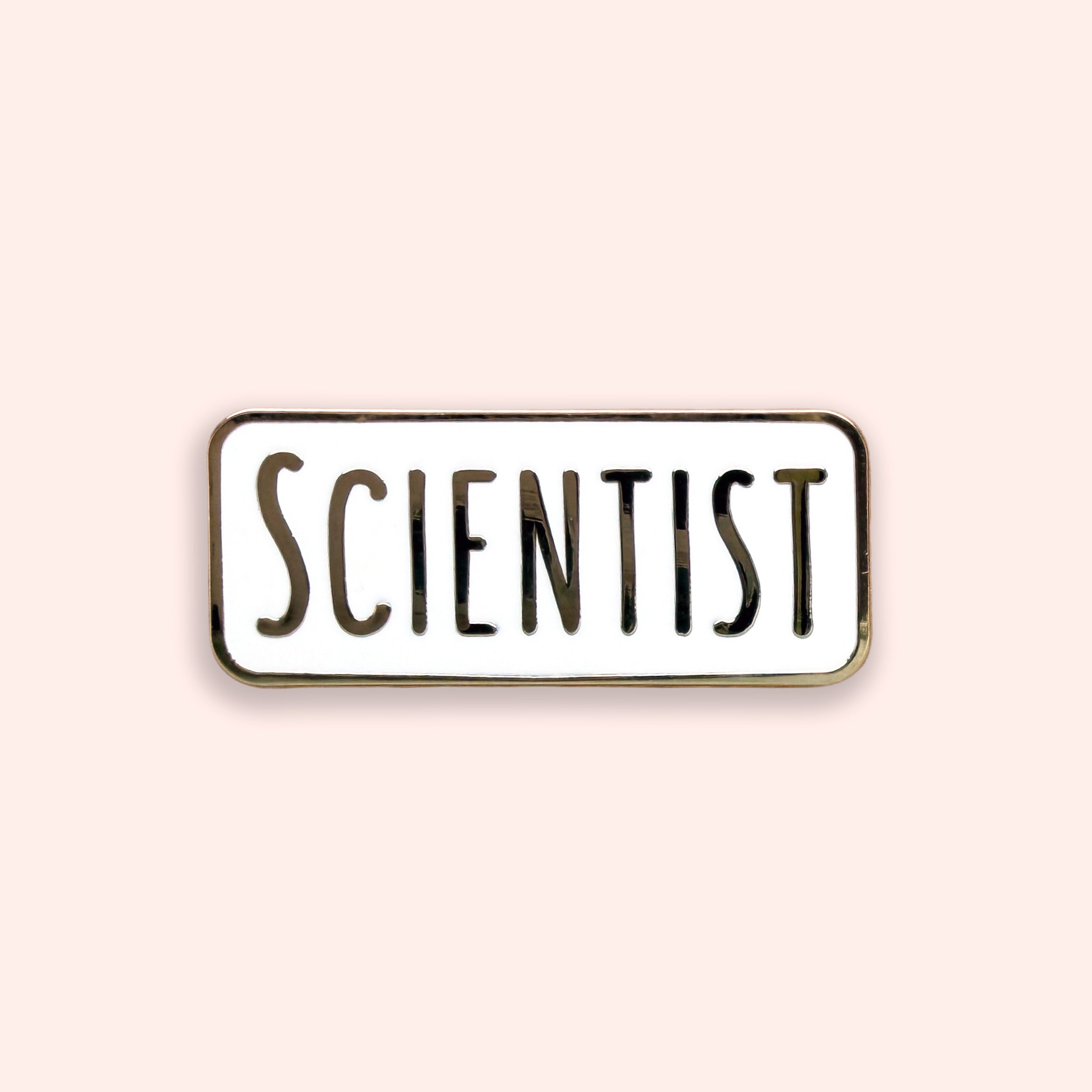 Enamel pin with 'SCIENTIST' text on a light pink background