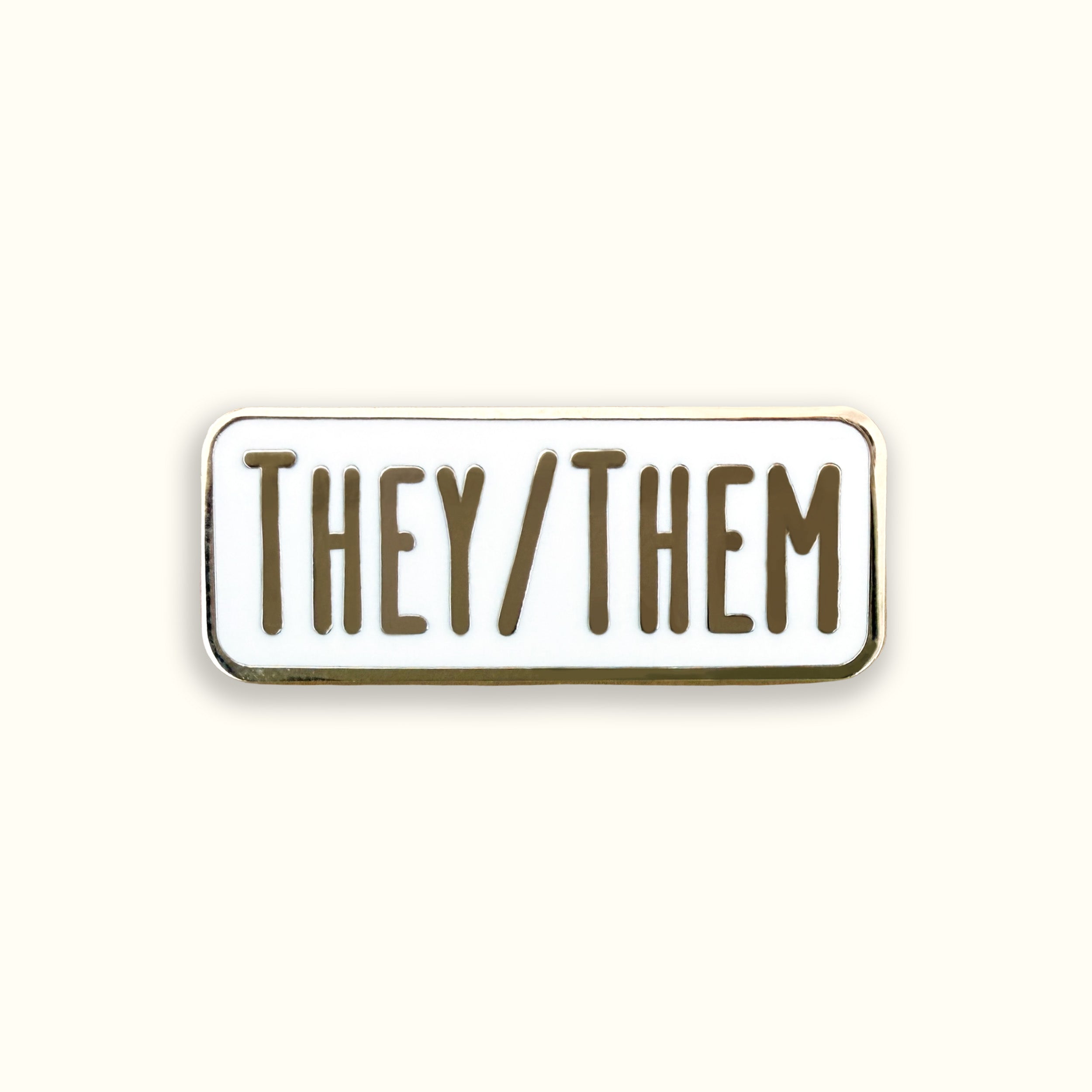 Enamel pin with 'THEY/THEM' text on a white background